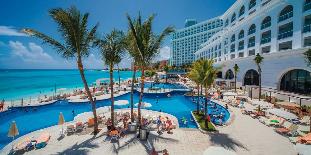 Pool and seafront hotel exterior — Hotel Riu Cancun