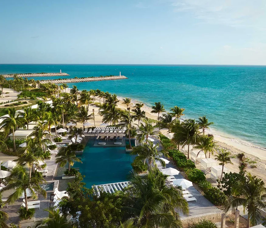 Seafront resort swimming pool and palms — SLS Playa Mujeres